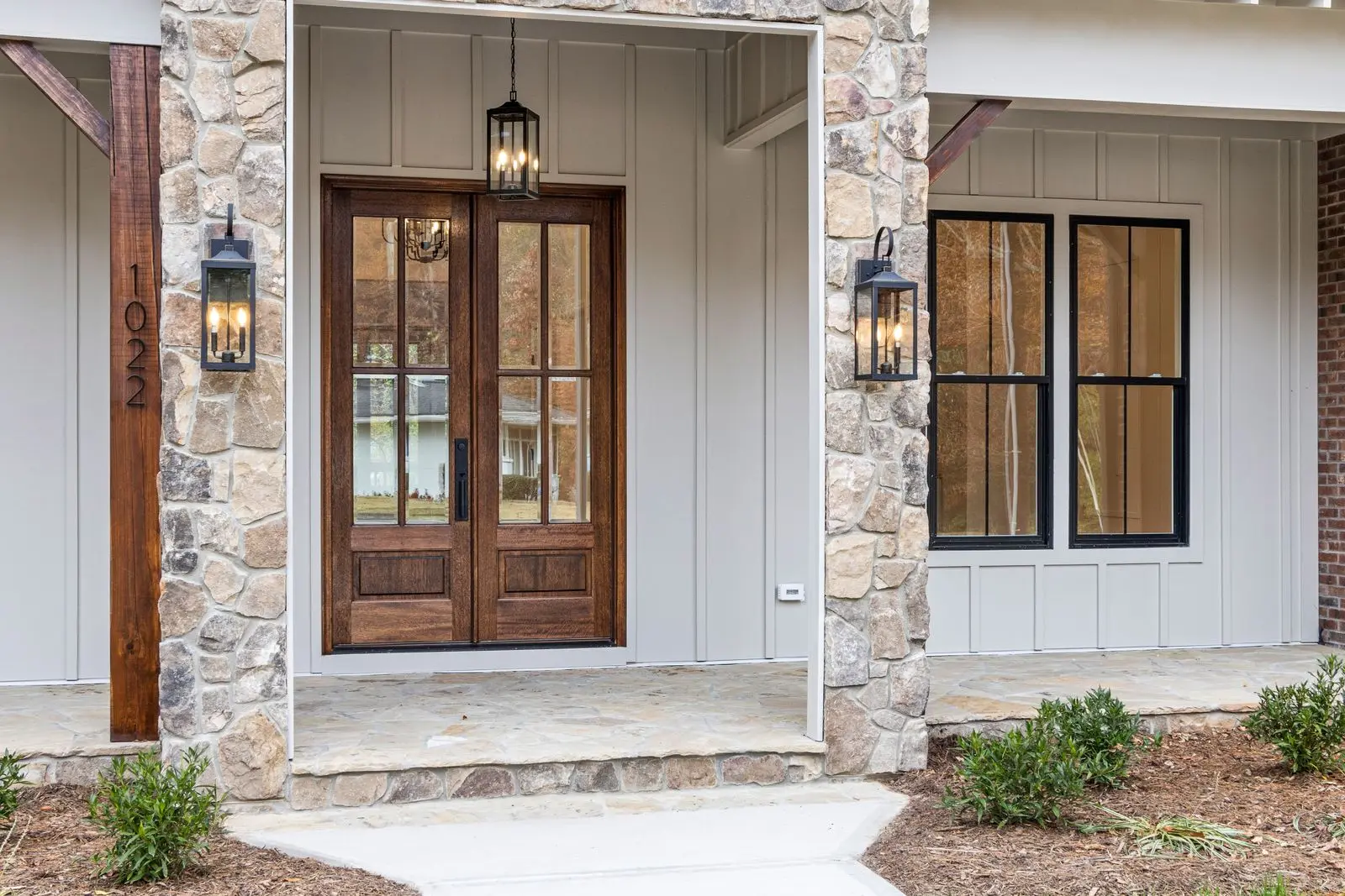 Luxury wood and glass front entry door with stone surround