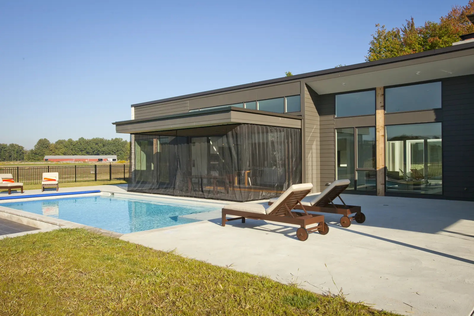 Panda® glass wall with integrated screens beside a pool at the Belfast Residence