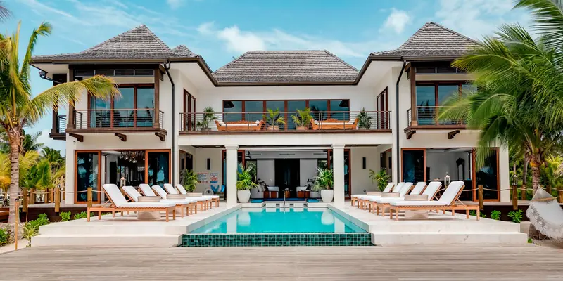 Two-storey villa with Panda® lift and slide doors across both levels facing a pool