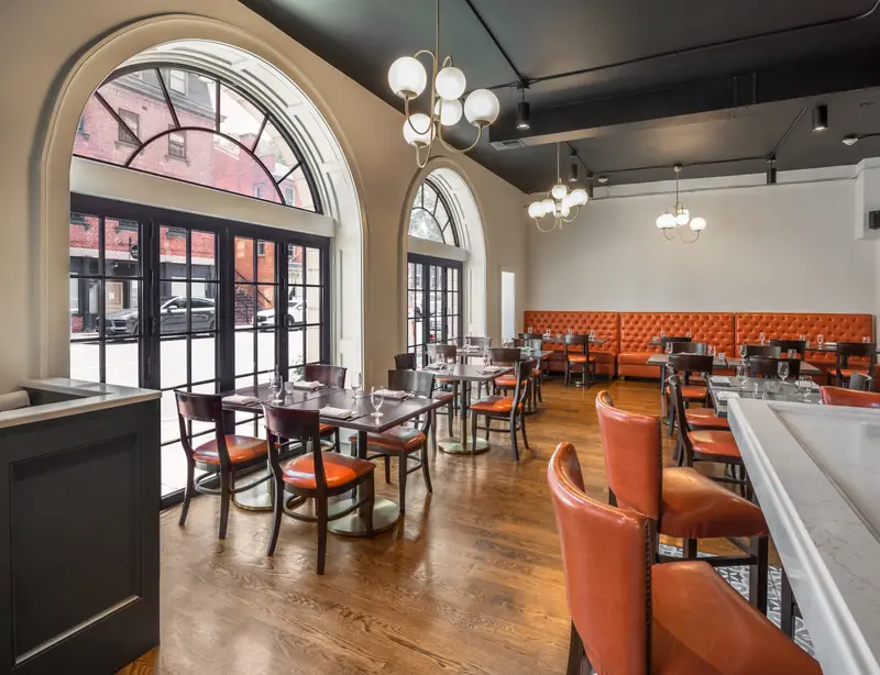Arched Panda® folding doors along a restaurant dining room in Providence, Rhode Island