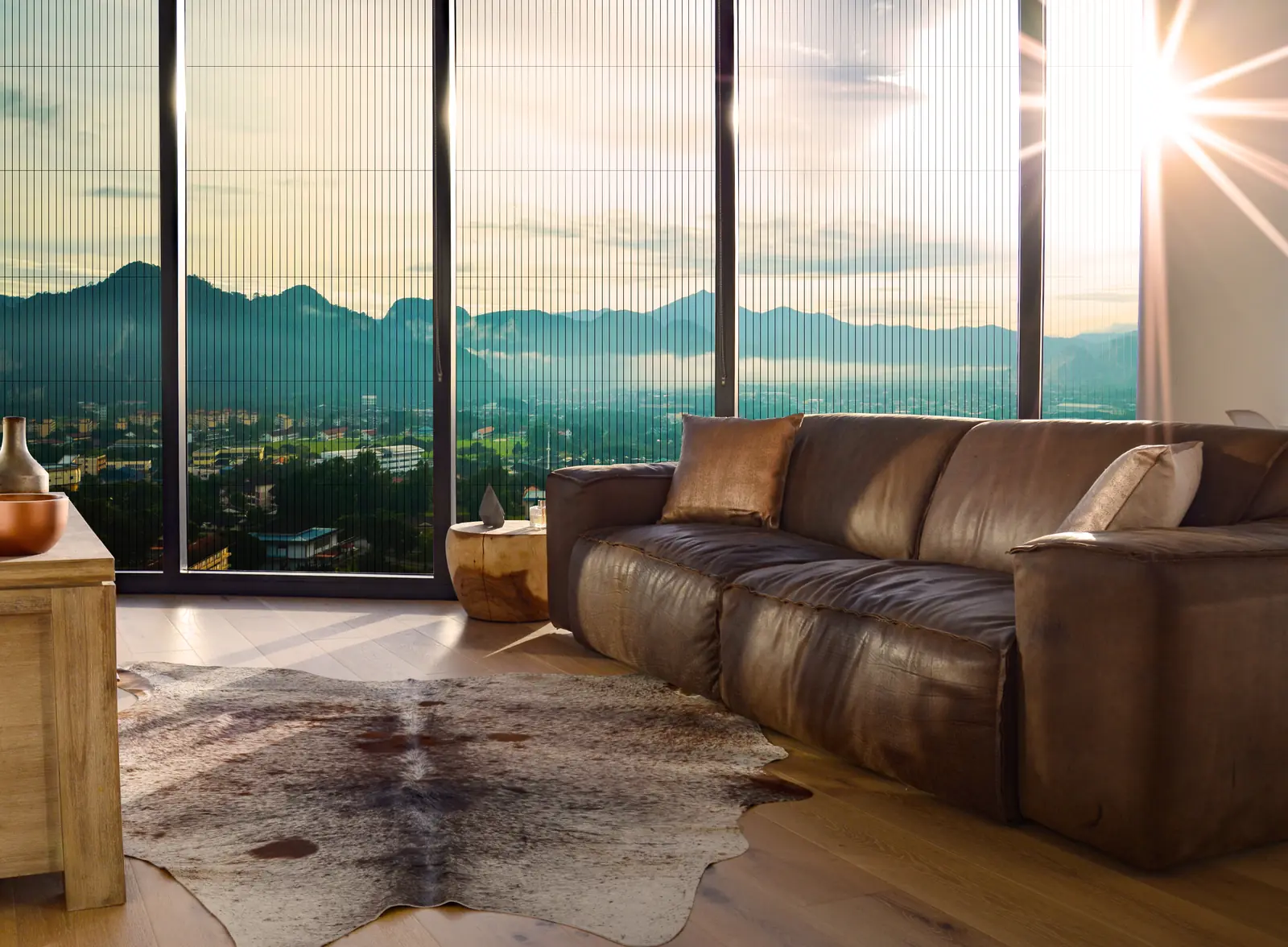 Panda® pleated retractable screen drawn across a floor-to-ceiling glass wall facing a mountain view