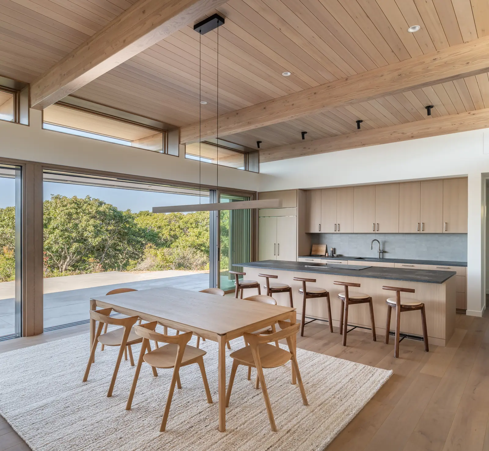Panda® aluminum-clad wood lift and slide doors along a kitchen and dining room in Massachusetts