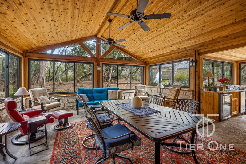 Enclosed porch with bronze windows on three sides and a kitchenette beyond