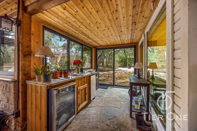Bronze slider and corner windows beside a porch kitchenette