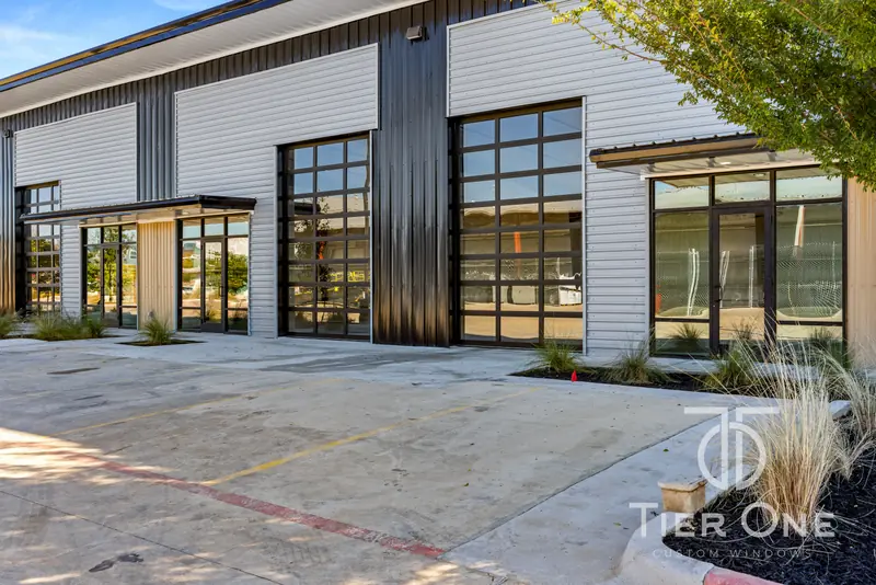 Storefront entry beside two full-view glass overhead doors