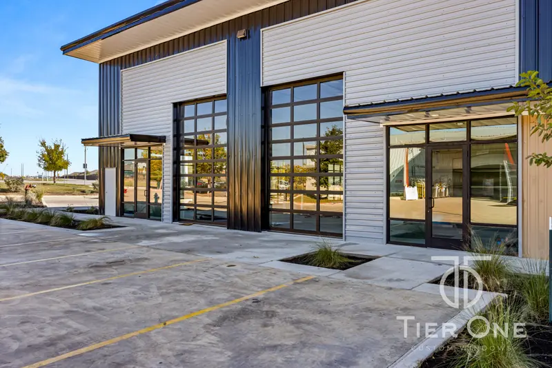 Glass overhead doors and a storefront entry at the end of the building