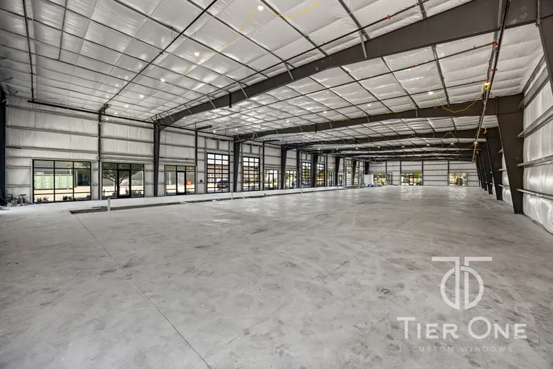 Open warehouse floor with storefront glazing along the front wall