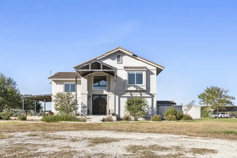 Two-storey stucco ranch house with new white-framed windows