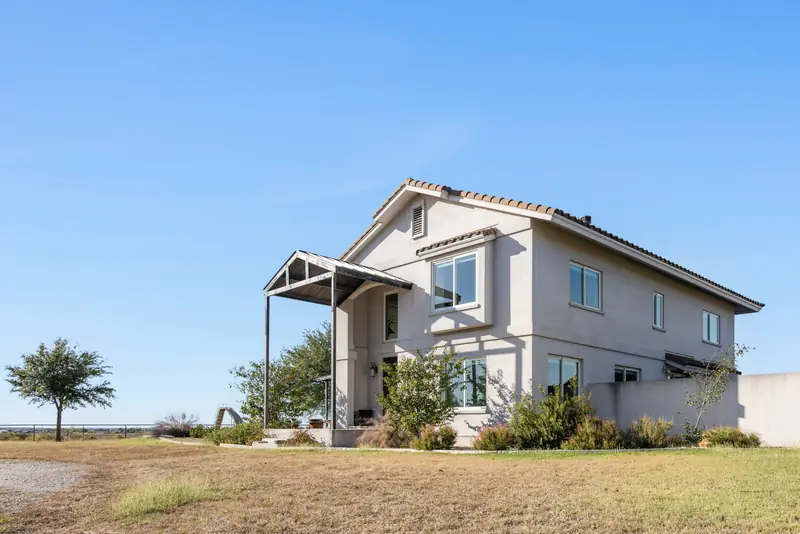 Side elevation of a stucco ranch house with new windows