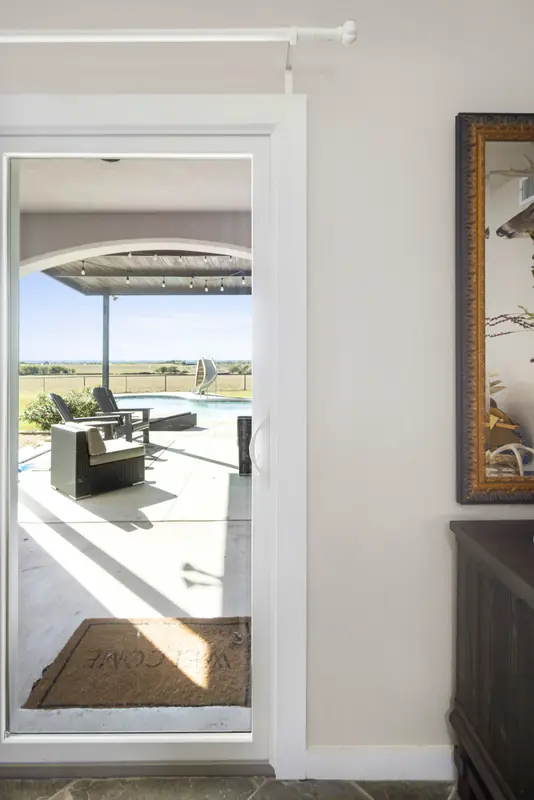 White-framed glass door opening onto the covered pool patio