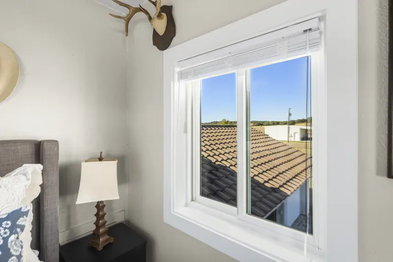 White sliding window above a tile roof
