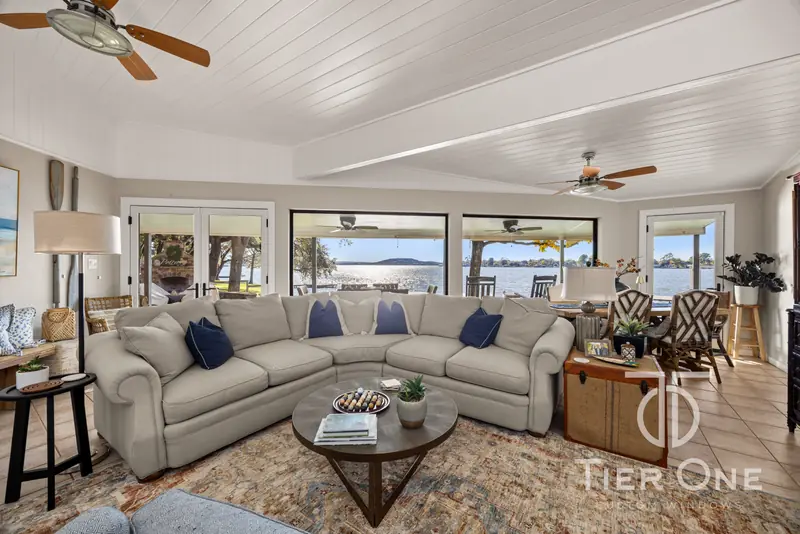 Lakeside living room with French doors and a wall of black-framed windows