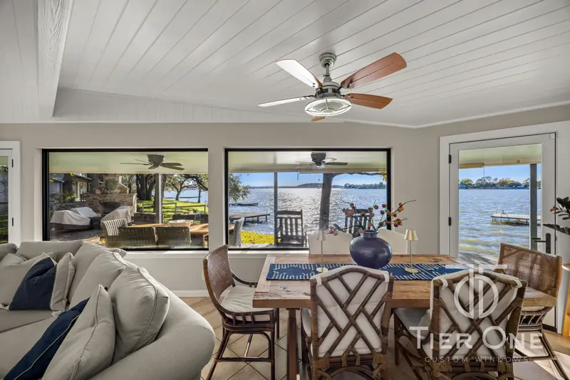 Dining room with black-framed windows and a patio door onto the lake