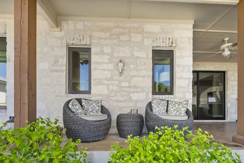 Porch-facing windows and a sliding door in a limestone wall
