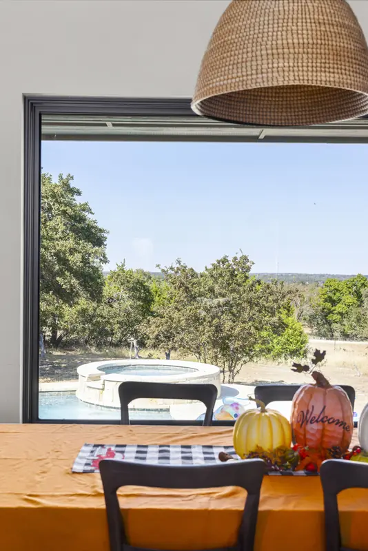 Picture window framing the spa and hill country view