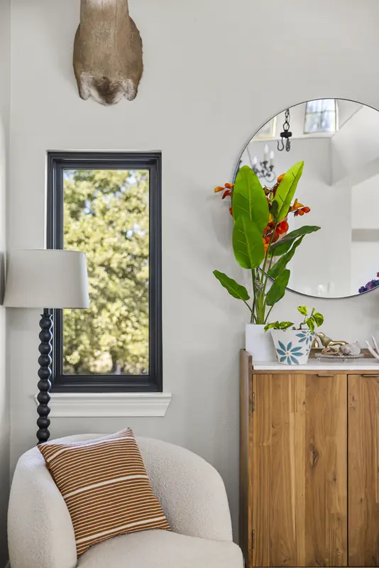 Narrow black-framed window beside a console table