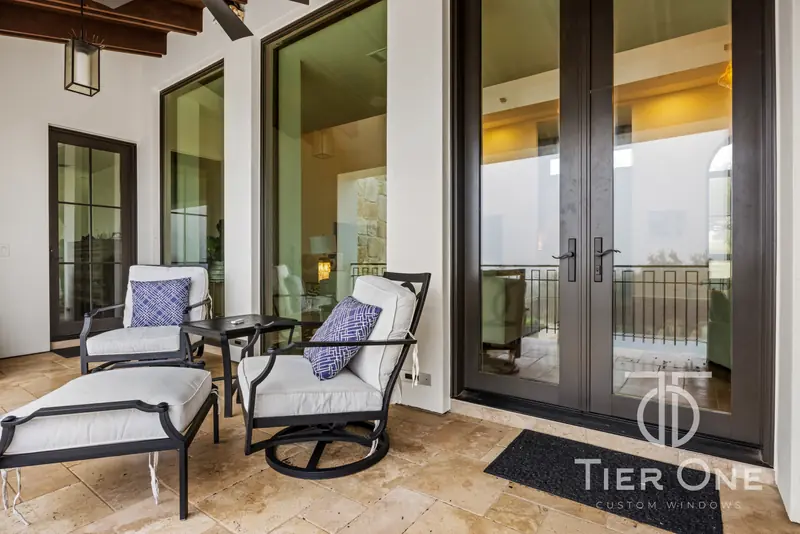 Dark-framed French doors and windows along a covered balcony