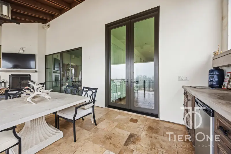 Dark-framed French door beside an outdoor dining table
