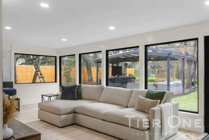 Run of black-framed windows along a sunroom looking onto the patio
