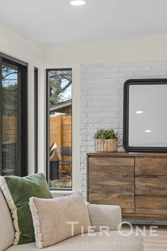 Black-framed windows on either side of a painted brick wall