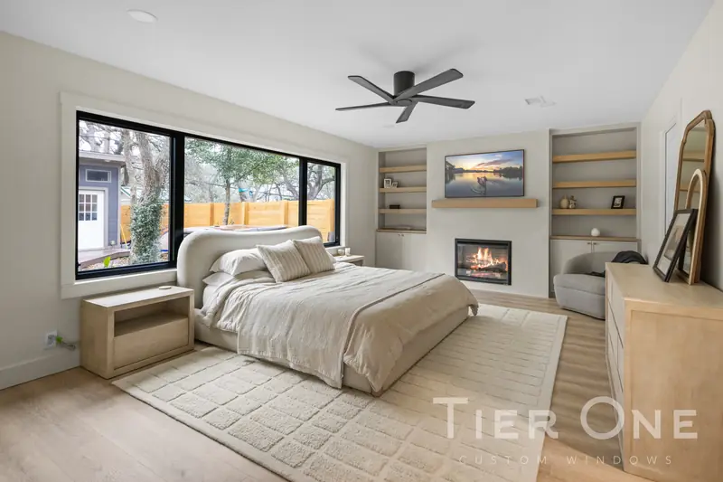 Black-framed window beside the fireplace in a primary bedroom