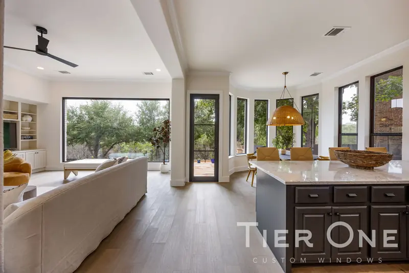 Breakfast nook ringed with tall black-framed windows and a glass door