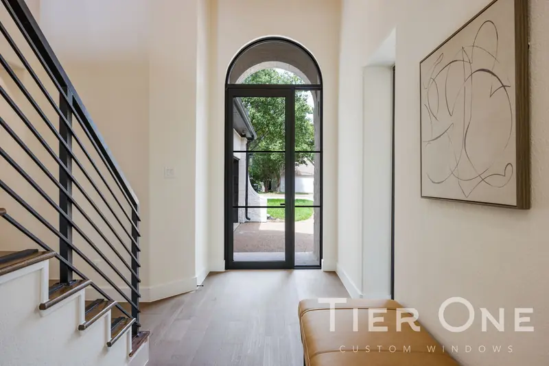Arched black steel-look glass entry door at the end of the front hall