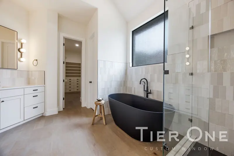 Obscure-glass window above a freestanding black tub