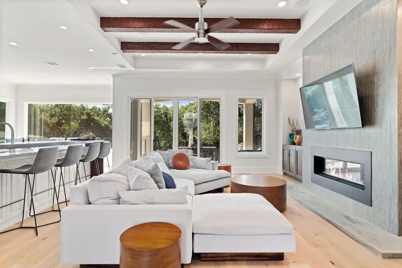 Open living room with a sliding door and windows on either side of the fireplace