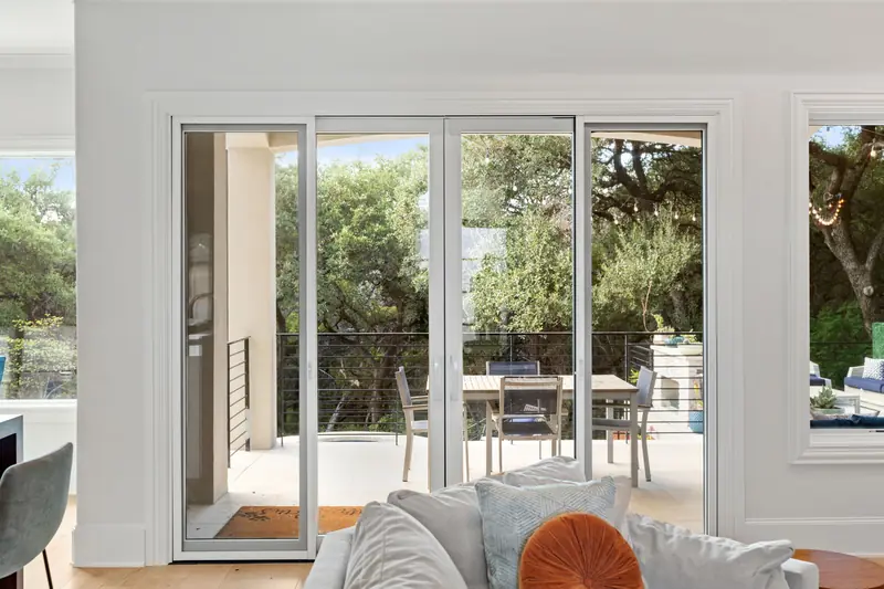 Multi-panel white-framed sliding door opening onto a covered patio