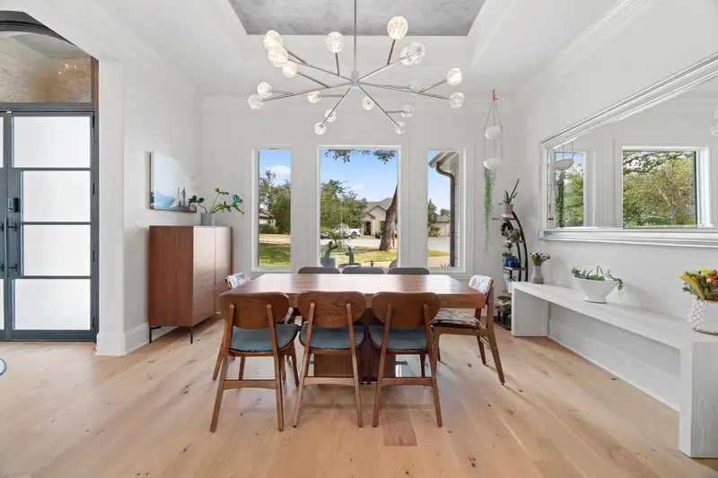 Three tall windows and a glass entry door in the formal dining room