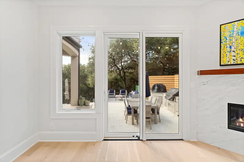 White-framed patio door and side window opening onto the outdoor kitchen