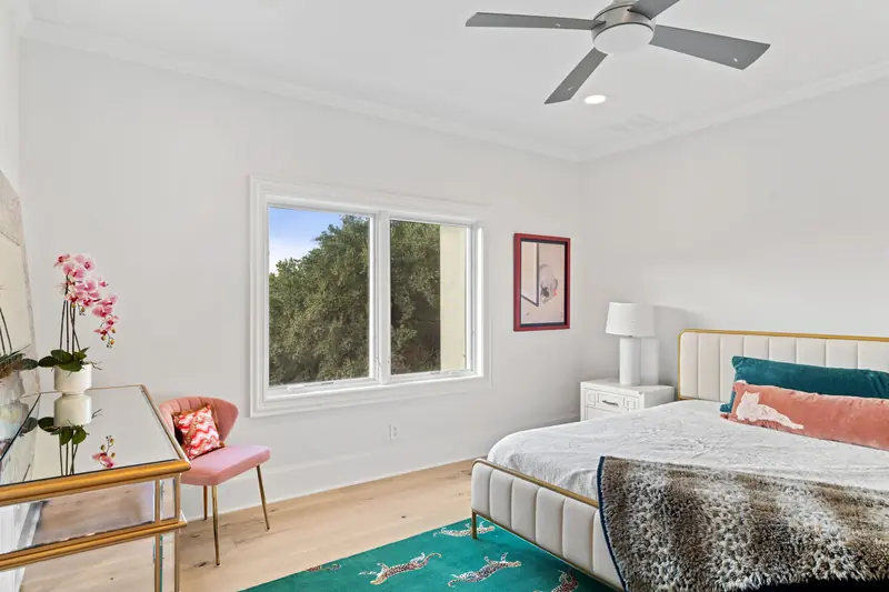 Bedroom with a white-framed window pair above a dressing table