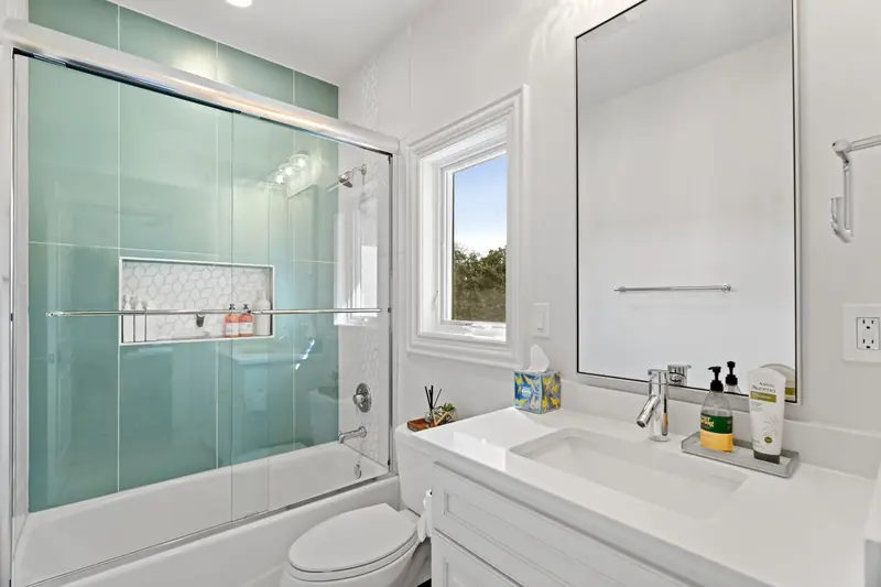 White-framed window beside a vanity and glass shower