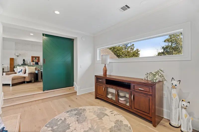 Long horizontal clerestory window above a media console on the landing