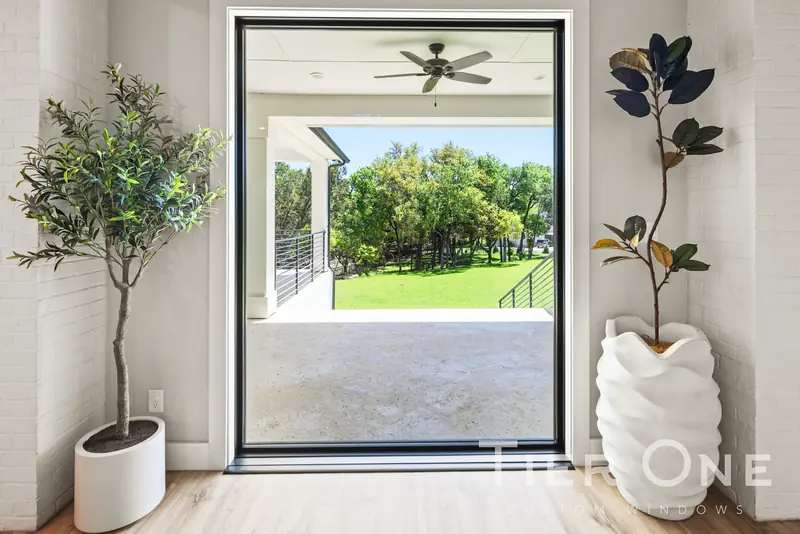 Floor-to-ceiling black-framed picture window onto a covered porch