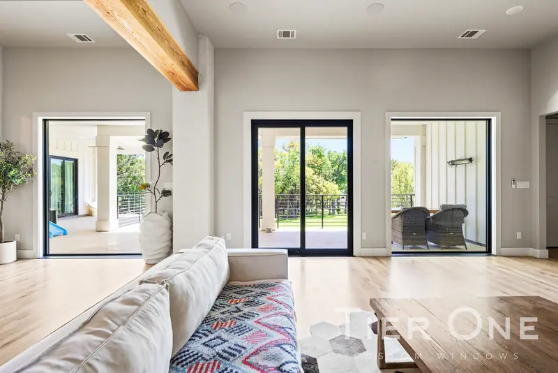 Living room with black sliding doors and a picture window to the porch