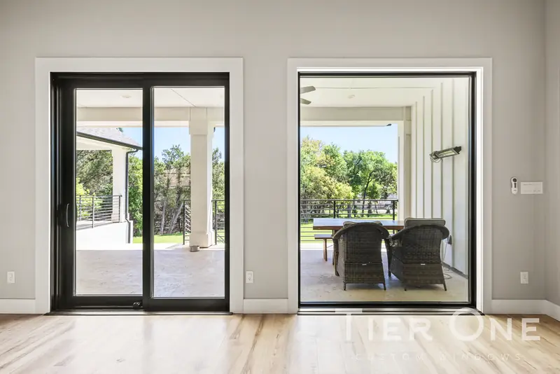Black sliding door and picture window side by side facing the porch