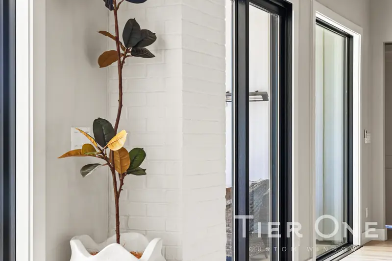 Tall black-framed fixed units beside a white brick column