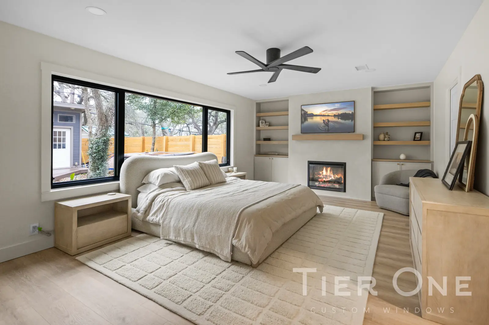 Wide black-framed picture window above the bed in a primary bedroom