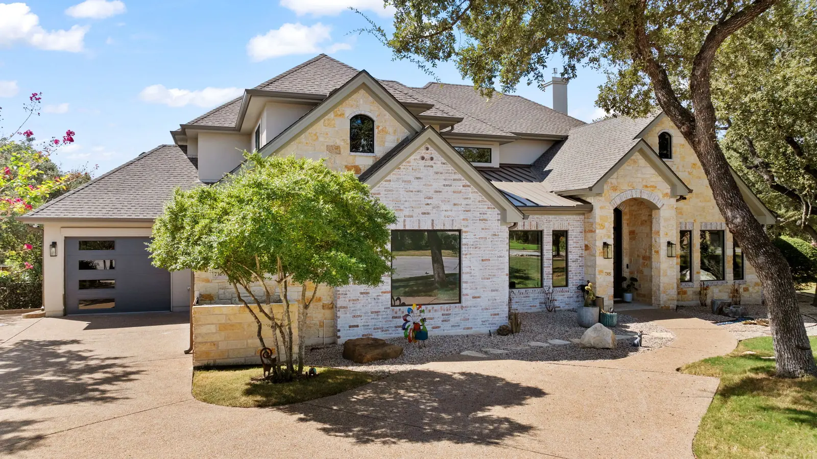Exterior street view of a two-storey stone and brick home with new windows and doors
