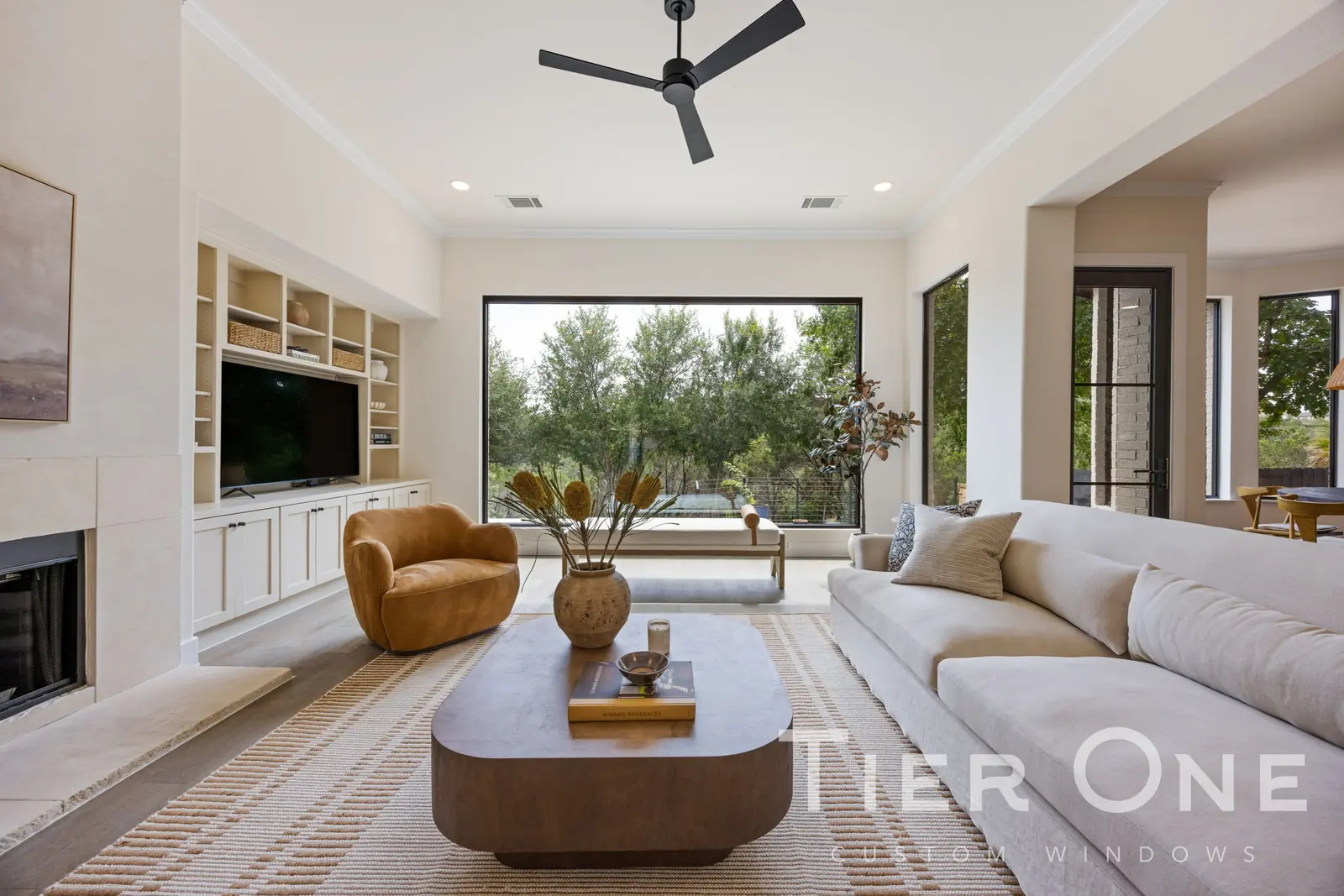 Black-framed picture window with flanking units in a living room overlooking trees