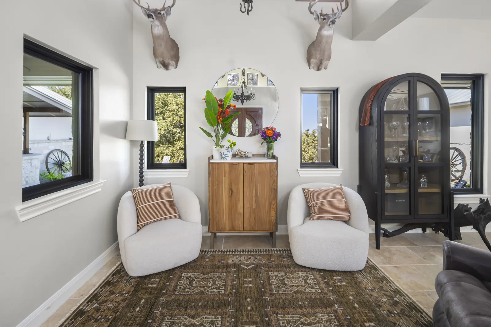 Black-framed windows on either side of a sitting room with travertine floors