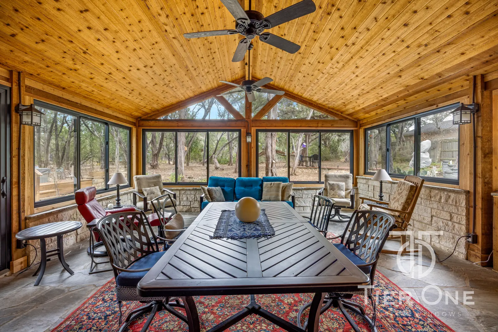 Gable-end window bank under a cedar plank ceiling on an enclosed porch