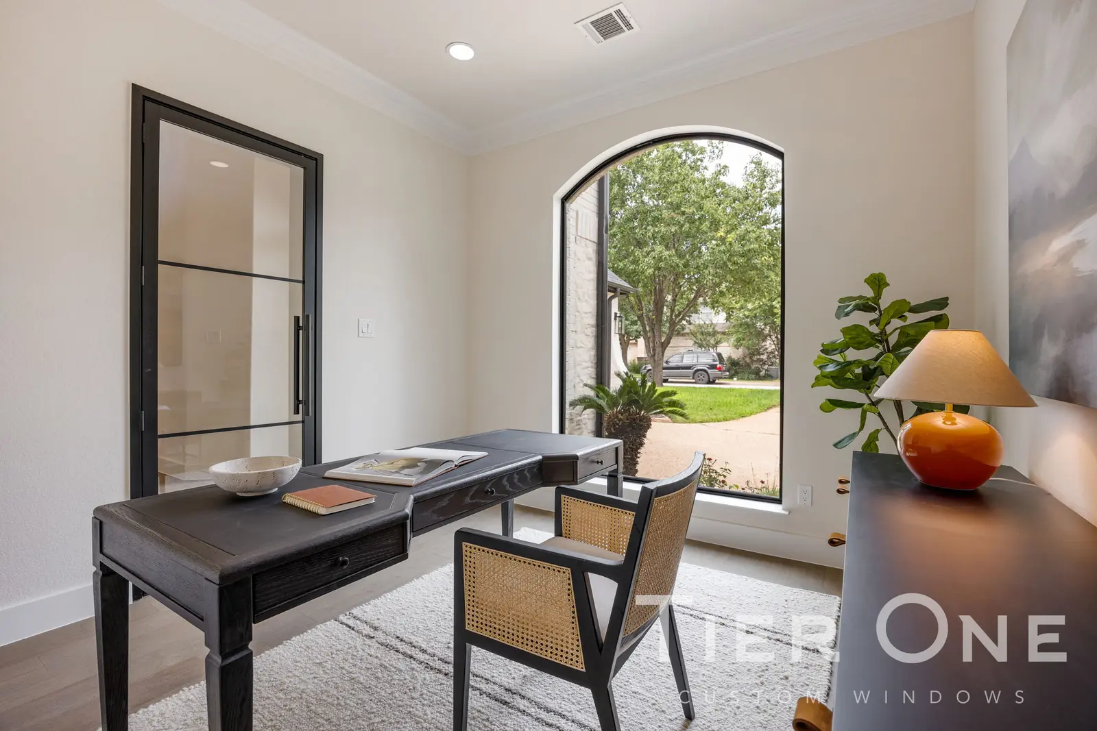 Arched window and black steel-look interior glass door in a home office