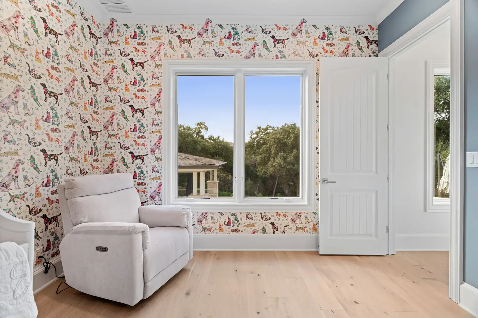White-framed window in a child's bedroom with patterned wallpaper